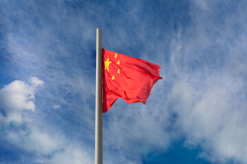 The national flag of China People's Republic of China waving against a cloudy sky
