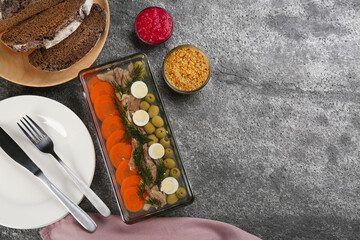 Fototapeta na wymiar Delicious aspic with meat and vegetables served on grey table, flat lay. Space for text