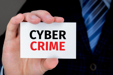 Businessman holding business card with CYBER CRIME text. Technology and finances concept.