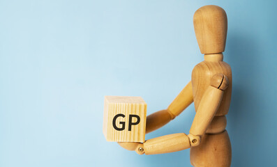 Wooden man holding a wooden cube with acronym GP-Gross profit. Business and finances concept.