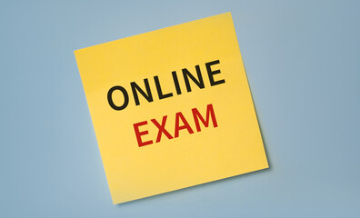 ONLINE EXAM text written on a sticker against blue background. Education concept.