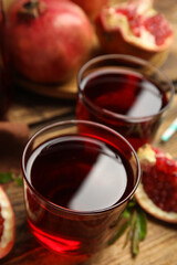 Pomegranate juice on wooden table, closeup view