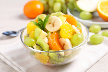Fototapeta na wymiar Delicious fresh fruit salad in bowl on table