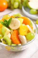 Delicious fresh fruit salad in bowl on table, closeup