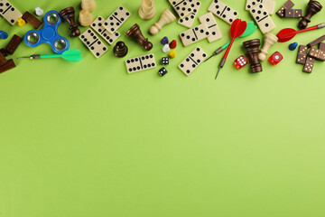 Components of board games on green background, flat lay. Space for text