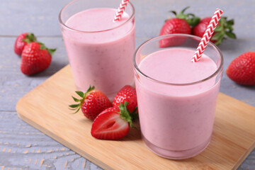 Delicious strawberry drink on light grey wooden table