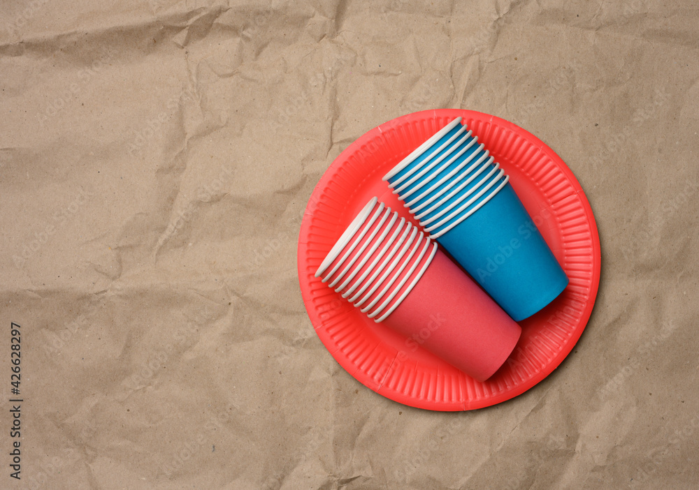 Poster stack of paper cups and round plates on a brown paper background