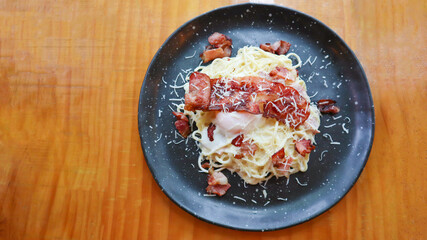 Carbonara spaghetti with onsen egg, crispy bacon, hard parmesan cheese and cream sauce.