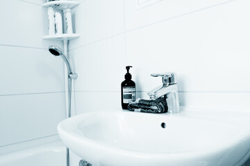 Water tap and liquid soap in the bathroom