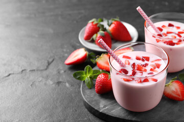 Delicious drink with strawberries on black table, space for text