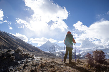 Successful woman backpacker hiking in winter high altitude mountains