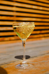 A glass with a cocktail, Shaman color, stands on the street