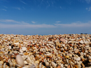 Wet rounded multi-colored gravel on the shores of the Adriatic Sea at sunset. Selective focus. Close-up