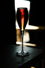 Glass of red cocktail with orange color