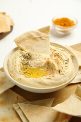 Delicious hummus with pita chips on wooden board, closeup