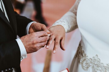 Pareja casándose. Anillo de boda en mano. Novios recién casados. Mano con alianza. 