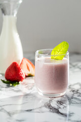 Indian traditional lassi drink with strawberries on a light background