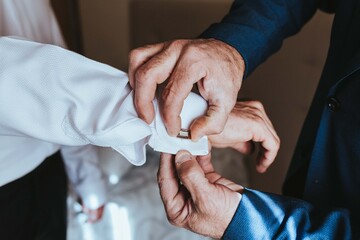 Novio vistiéndose. Poniendo gemelos de boda. Gemelos de matrimonio. Gemelos de boda. 