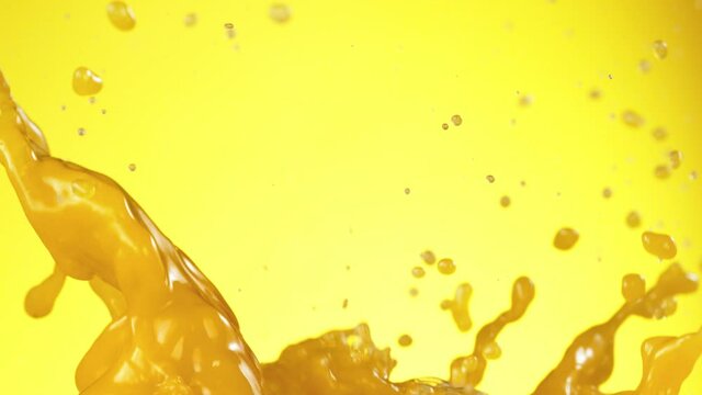 Super slow motion of fruit juice splashes on yellow background. Filmed on high speed cinema camera, 1000 fps.