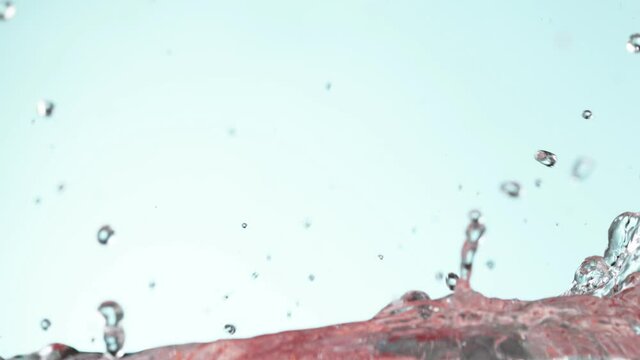 Super slow motion of falling strawberries into splashing water. Filmed on high speed cinema camera, 1000fps.