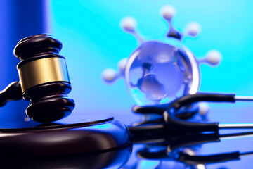 Medical law concept. Gavel and stethoscope on the glass table. Blue light.