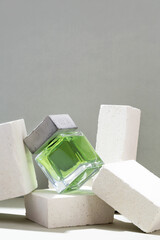 Glass bottle of essential oil and white stones on the table