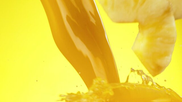 Super slow motion of pineapple slices falling into juice. Filmed on high speed cinema camera, 1000 fps.