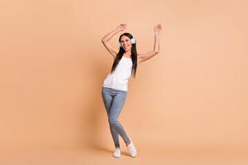 Fototapeta na wymiar Full length photo portrait of girl in earphones dancing isolated on pastel beige colored background