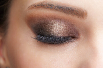 Closeup macro shot of closed human female eye. Girl with perfect skin and pink eyes shadows