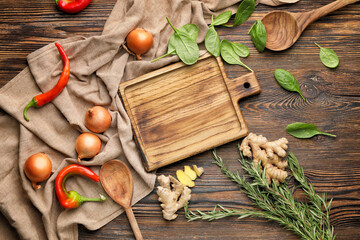 Cutting board with herbs and spices on wooden background