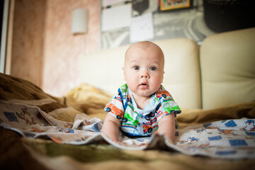Adorable boy in the bedroom. A newborn baby is resting in bed. Family morning at home. A newborn baby is lying on his stomach