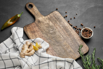 Cutting board with spices on dark background