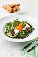 Healthy salad with persimmons on a rustic background. Vegetarian menu, healthy food. Prevention of vitamin deficiency.