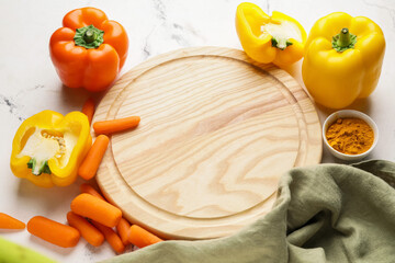 Cutting board with vegetables on light background