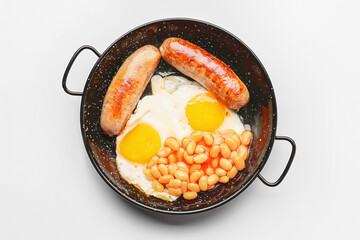 Frying pan with traditional English breakfast on white background