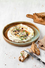 Feta with herbs, spicy honey and mini baguette on a plate on a rustic background. Vegetarian menu, healthy food.