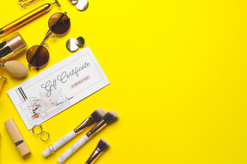 Gift certificate, decorative cosmetics and female accessories on color background