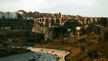 Fototapeta premium CONSTANTINE, ALGERIA - View of stone bridges and old houses on the cliff at Constantine, Algeria. Panorama of Constantine city, Algeria 