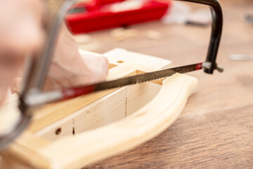 Sawing a wooden product with a hand saw. Carpentry works. Hobby. 