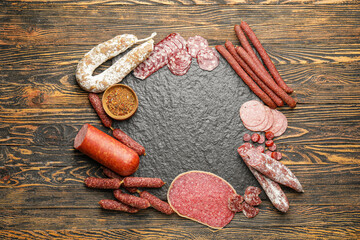 Frame made of different sausages on wooden background