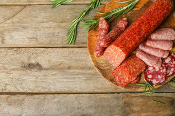 Plate with tasty sausages on wooden background