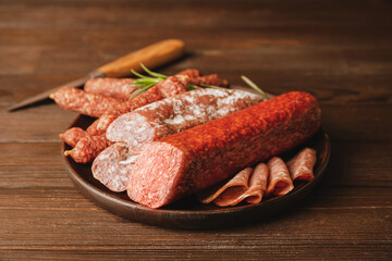 Plate with tasty sausages on wooden background