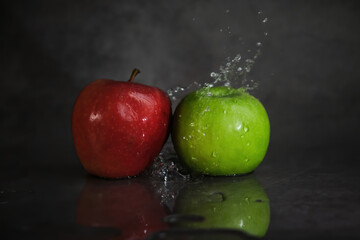 red and green apples in splashes of water