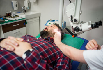 Doctor in hospital checking patient the ear