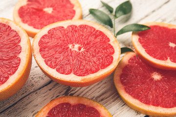 Fresh sliced grapefruit on white wooden background