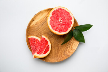 Plate with fresh sliced grapefruit on white background