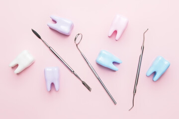 Dentist's tools and plastic teeth on color background