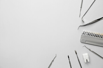Naklejka premium Dentist's tools and teeth color samples on light background