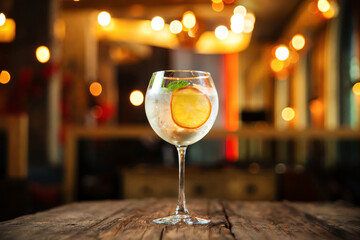 Side view on glass of gin tonic cocktail with orange slice