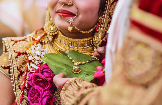 Young Indian bride wearing an ethnic traditional outfit and heavy gold jewellery